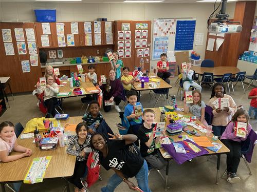 Students celebrating new books with the teen volunteers